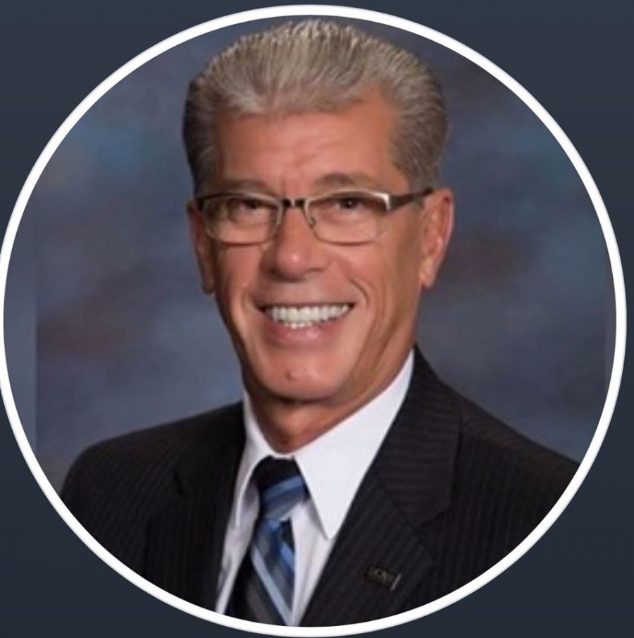 headshot of a man on blue background